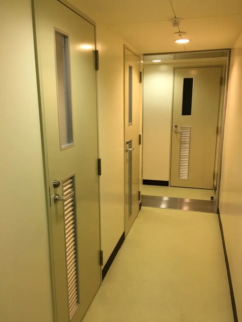 人1.5人分くらいの幅の廊下。個室ごとに扉がついている。